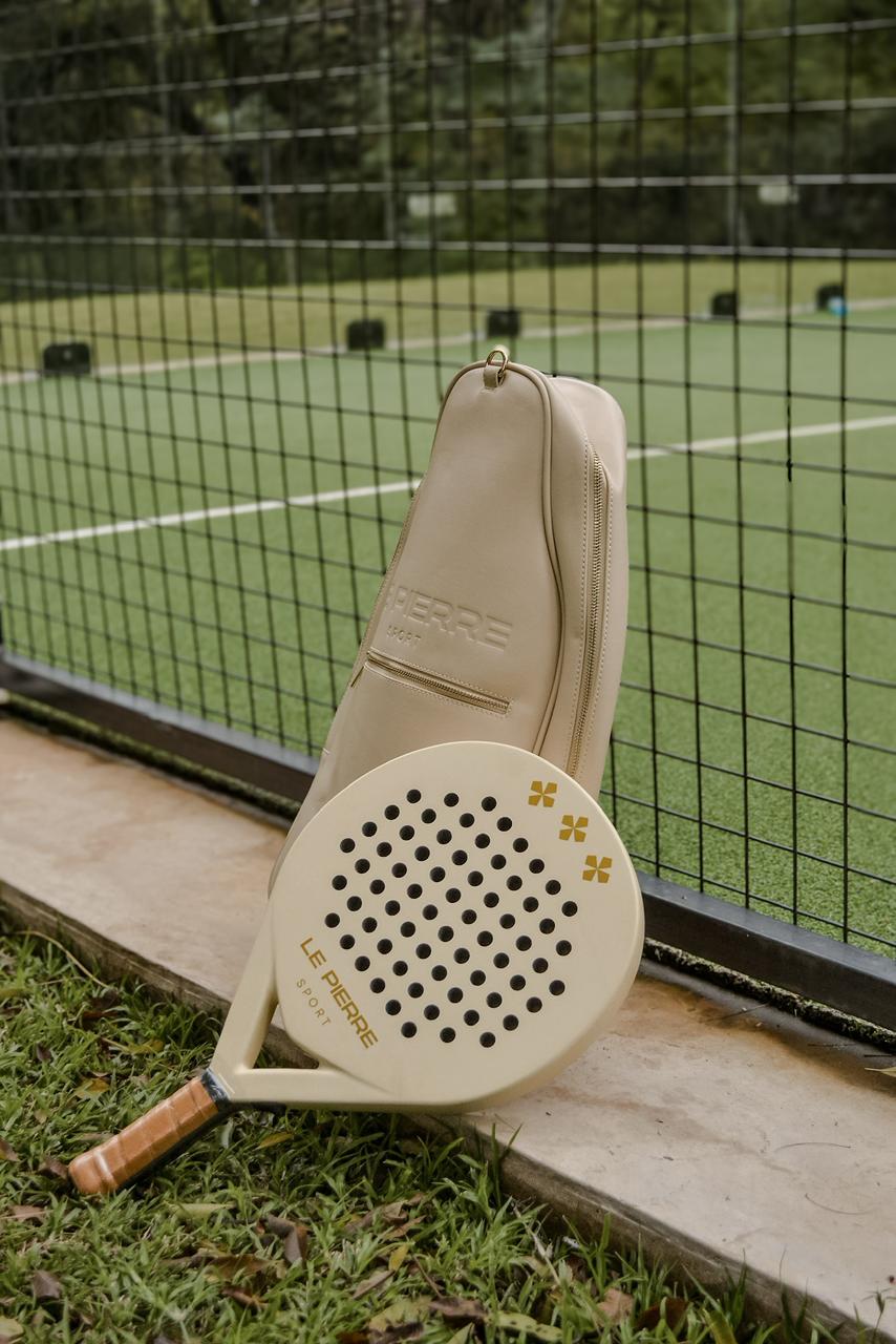 Le Pierre Sport padel bag and racket leaning by the court